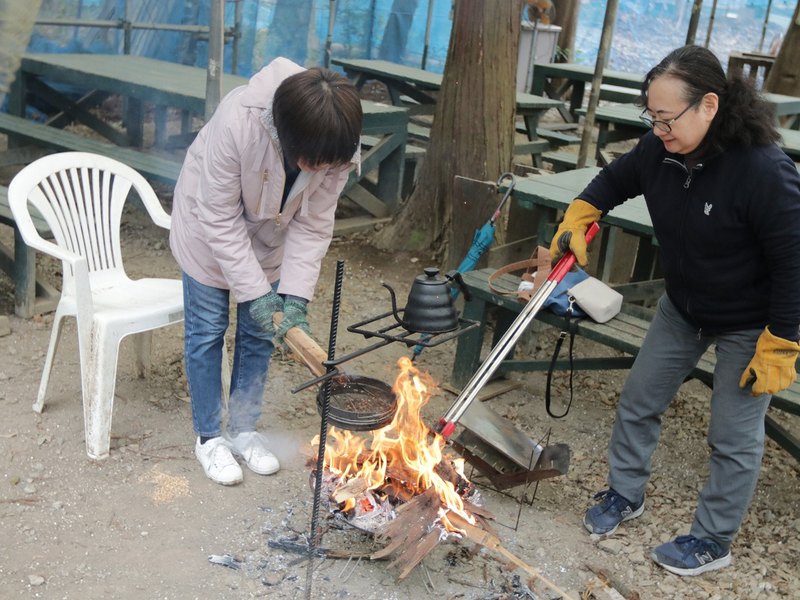 ベンチのそばで焚き火をおこす様子